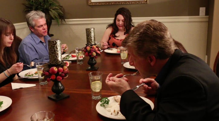 Clients and staff sharing a meal at a dining table